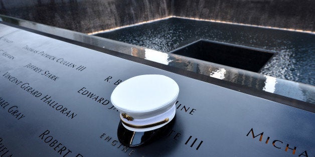 A firefighter's hat sits on names of firefighters who died at the South Pool, during anniversary ceremonies at the site of t