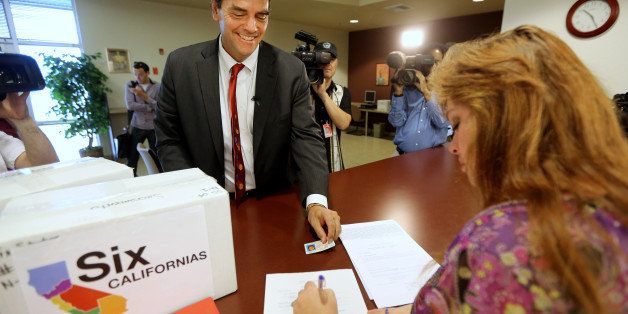 Silicon Valley venture capitalist Tim Draper presents his drivers license for identification purposes to Heather Ditty, elections manager for the Sacramento County Registrar of Voters, as he turns in boxes of petitions for a ballot initiative that would ask voters to split California into six separate states, Tuesday, July 15, 2014, in Sacramento, Calif. Draper delivered what he said were 44,000 signatures, of the 1.3 million the Six California's campaign plans to submit statewide this week. If enough signatures are verified, voters in November 2016 would be asked to divide the state into six states called Jefferson, North California, Silicon Valley, Central California, West California and South California. (AP Photo/Rich Pedroncelli)
