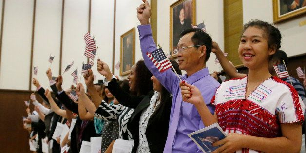 Eh Pree, nineteen years old, of Burma, waves a flag as she participates in a Naturalization Ceremony in Oklahoma City, Friday, June 27, 2014. Fifty-one individuals from 24 countries took the Oath of Allegiance to the United States as their final step to become citizens. (AP Photo/Sue Ogrocki)