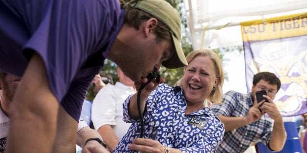 UNITED STATES - SEPTEMBER 20: Sen Mary Landrieu, D-La., holds the beer keg nozzle for LSU football fan as he does a keg stand at a tailgate party on the Louisiana State University campus before the LSU-Mississippi State game on Saturday, Sept. 20, 2014. (Photo By Bill Clark/CQ Roll Call)