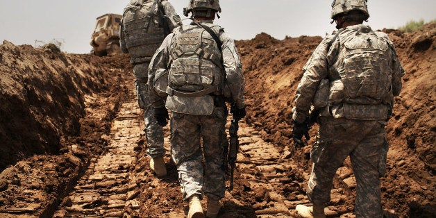 ISKANDARIYA, IRAQ - JULY 19: U.S. soldiers with the 3rd Armored Cavalry Regiment patrol a new ditch they have dug to protect