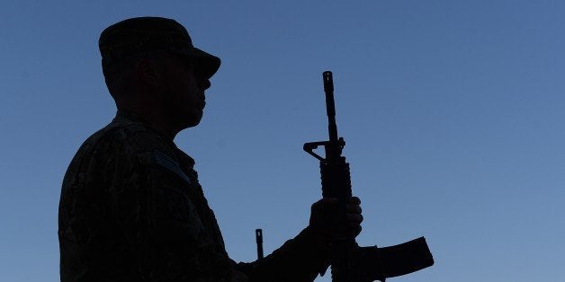 US soldiers participate in a memorial ceremony in remembrance of those who perished thirteen years ago during the 9/11 attacks in the US, at a military base in Bagram, 50 kms north of Kabul on September 11, 2014. Ceremonies were held in tribute to the victims of the 9/11 attacks at bases across Afghanistan where troops are stuck in a seemingly un-winnable war against a Taliban guerrilla movement few Americans understand. AFP PHOTO/SHAH Marai (Photo credit should read SHAH MARAI/AFP/Getty Images)