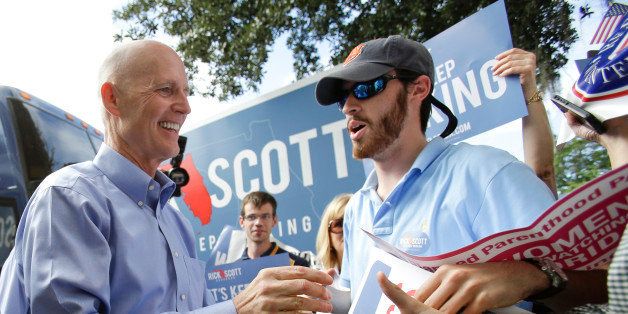 Florida Gov. Rick Scott, left, greets supporters as he arrives at a campaign event Monday, Sept. 8, 2014, in Winter Park, Fla. Scott is running against former Republican Gov. Charlie Crist, who is running as a Democrat in November's election for Florida governor. (AP Photo/John Raoux)