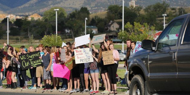 Students protest outside of Ralston Valley High School, as a motorist passes by, Tuesday, Sept. 23, 2014, in Arvada, Colo. The students are protesting a proposal by the Jefferson County School Board to emphasize patriotism and downplay civil unrest in the teaching of U.S. history. (AP Photo/Brennan Linsley)