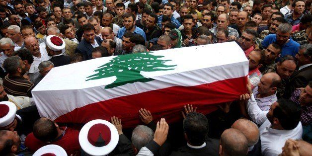Lebanese mourners carry the coffin of Sgt. Ali Sayid who was beheaded by Islamic militants, during his funeral procession at his home town in Fnaydek, Akkar north Lebanon, Wednesday, Sept. 3, 2014. Sayid went missing around the same time that some two dozen soldiers and police were seized by militants from Syria who overran the border town of Arsal for several days last month. The incursion was the most serious spillover yet of the Syrian civil war and escalated tensions in Lebanon, which is bitterly split over the conflict. (AP Photo/Hussein Malla)