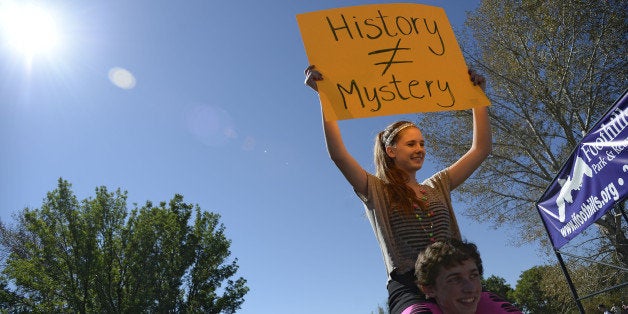 LITTLETON, CO - SEPTEMBER 25: Otto Schloegl, Senior holds Jennifer Zigler, Senior on his shoulders as she holds up a sign during Columbine High School students walk out September 25, 2014 to protest proposed AP History changes as they line up along Bowles Ave in Littleton. (Photo by John Leyba/The Denver Post via Getty Images)