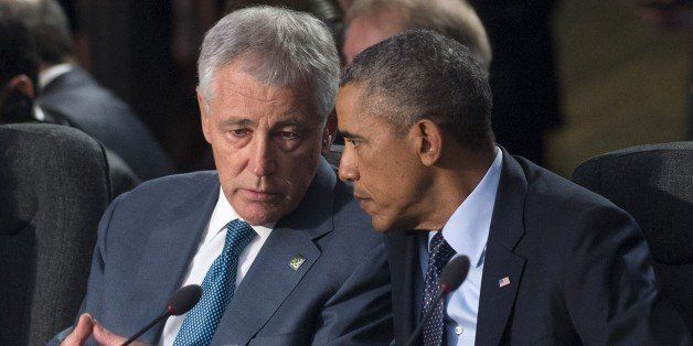 US President Barack Obama (R) speaks with US Secretary of Defense Chuck Hagel during a meeting on the second day of the NATO 2014 Summit at the Celtic Manor Resort in Newport, South Wales, on September 5, 2014. NATO leaders are expected to announce a raft of fresh sanctions against Russia on Friday over its actions in Ukraine, although hopes remain that a ceasefire can be forged at peace talks in Minsk on the same day. AFP PHOTO / SAUL LOEB (Photo credit should read SAUL LOEB/AFP/Getty Images)