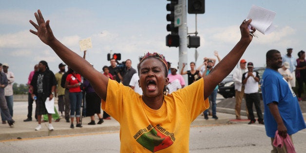 FERGUSON, MO - SEPTEMBER 10: Demonstrators protest near a ramp which leads onto Interstate Highway 70 on September 10, 2014 near Ferguson, Missouri. The demonstrators had planned to shut down I70 but their efforts were thwarted by a large contingent of police from several area departments. Ferguson, in suburban St. Louis, is recovering from nearly two weeks of violent protests that erupted after teenager Michael Brown was shot and killed by Ferguson police officer Darren Wilson last month. (Photo by Scott Olson/Getty Images)