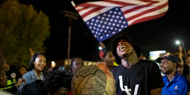 FERGUSON, MO - SEPTEMBER 30: Protesters gather in front of the police department on September 30, 2014 in Ferguson, Missouri. Protests continued in the St. Louis suburb after the fatal police shooting of Michael Brown. (Photo by Whitney Curtis/Getty Images)