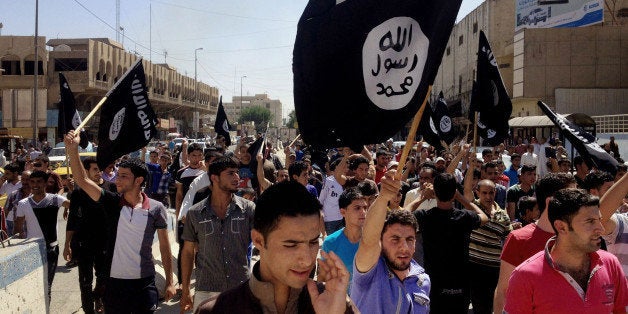 FILE - In this June 16, 2014 file photo, demonstrators chant pro-Islamic State group slogans as they carry the group's flags in front of the provincial government headquarters in Mosul, 225 miles (360 kilometers) northwest of Baghdad. Branding experts say an unfortunate association with a name, like businesses and brands who share the name "Isis" with the notorious Islamic militant group, can scar a companyâs reputation with customers even if the connection is just coincidental. (AP Photo, File)