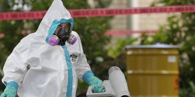 A hazmat worker clean outside the apartment building of a hospital worker, Sunday, Oct. 12, 2014, in Dallas. The Texas health care worker, who was in full protective gear when they provided hospital care for Ebola patient Thomas Eric Duncan, who later died, has tested positive for the virus and is in stable condition, health officials said Sunday. (AP Photo/LM Otero)