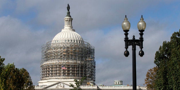 Scaffolding begins to obscure the Capitol Dome in Washington, Tuesday, Oct. 14, 2014, for a long-term repair project to fix c