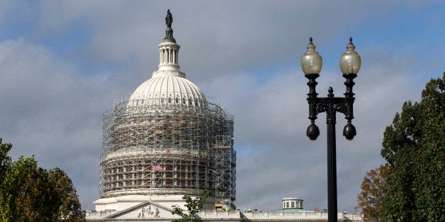 Scaffolding begins to obscure the Capitol Dome in Washington, Tuesday, Oct. 14, 2014, for a long-term repair project to fix cracks, leaks and corrosion in the cast-iron structure. (AP Photo/J. Scott Applewhite)