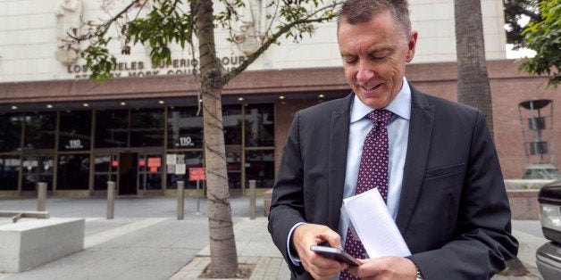In this June 10, 2014, photo, Los Angeles Unified School District Superintendent John Deasy checks his phone outside the Stan
