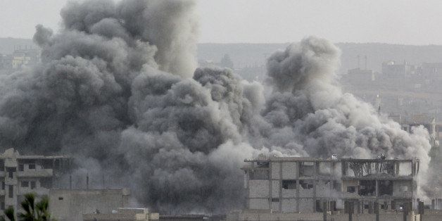 SURUC, SANLIURFA - OCTOBER 16: A photograph taken from Suruc district of Sanliurfa, Turkey, shows smoke rising from the Syrian border town of Kobani (Ayn al-Arab) following the US-led coalition airstrikes against the Islamic State of Iraq and the Levant (ISIL) on October 16, 2014. (Photo by Murat Kula/Anadolu Agency/Getty Images)