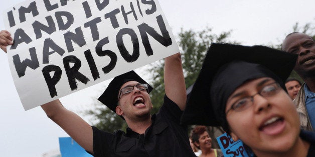 AVENTURA, FL - MAY 31: Carlos Roa (L) and Frida Barreto join a group of protesters delivering 12,000 signatures from a national petition to the office of Rep. Debbie Wasserman Schultz (D-FL) asking to stop the building of a CCA immigration detention center in South Florida on May 31, 2012 in Aventura, Florida. Since 2011, residents of Southwest Broward, immigrant communities and diverse advocates have been working to stop the building of the immigration prison in the town of Southwest Ranches by for-profit prison giant, Corrections Corporation of America (CCA). (Photo by Joe Raedle/Getty Images)