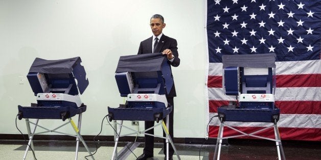 US President Barack Obama casts an electronic ballot while participating in early voting October 20, 2014 in Chicago, Illinois. While campaigning and fundraising for Democrats, Obama took the opportunity to early vote in the 2014 US midterm elections. AFP PHOTO/Brendan SMIALOWSKI (Photo credit should read BRENDAN SMIALOWSKI/AFP/Getty Images)