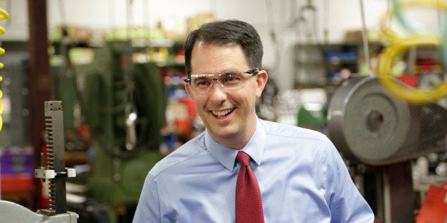 In this Sept. 23, 2014 photo Wisconsin Repubican Gov. Scott Walker makes a re-election campaign stop at a small business in Racine, Wis. A federal judge on Tuesday, Oct. 14, 2014 put on hold Wisconsinâs law limiting coordination between third-party groups and political candidates. The lawÂ is at the center of an investigation into Walker's 2012 recall campaign and more than two dozen conservative groups. (AP Photo/Darren Hauck)