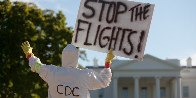 WASHINGTON, DC - OCTOBER 17: Jeff Hulbert of Annapolis, Maryland, holds up a sign in front of the White House on October 17, 2014 in Washington, D.C. Hulbert is protesting the entry of Ebola into the country through air travel. 'There should be a temporary travel ban on visitors from infected regions until medical infrastructure can get up to speed,' said Hulbert. (Photo by Allison Shelley/Getty Images)