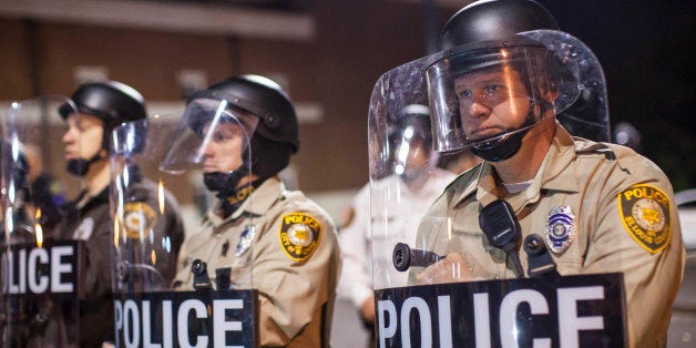 FERGUSON, MO - OCTOBER 11: St. Louis County Police Officers stand guard in front of the Ferguson Police Department during a protest against the shootings of Michael Brown on August 11, 2014 in Ferguson, Missouri. (Photo by Samuel Corum/Anadolu Agency/Getty Images)