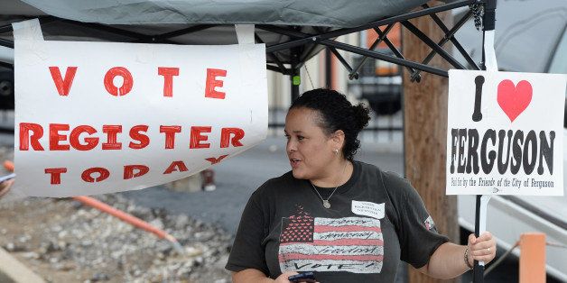 Shiron Hagens, of St. Louis, looks to register voters at a rally in Ferguson, Mo. on Saturday, Aug. 30, 2014 near the site where Michael Brown, an unarmed black 18-year-old, was fatally shot by a white police officer three weeks earlier. (AP Photo/Bill Boyce)
