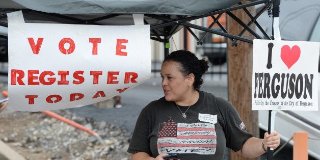 Shiron Hagens, of St. Louis, looks to register voters at a rally in Ferguson, Mo. on Saturday, Aug. 30, 2014 near the site wh