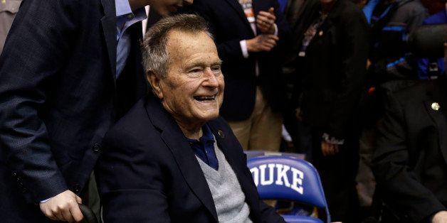 Former President George H.W. Bush is greeted prior to an NCAA college basketball game between Duke and North Carolina State at Cameron Indoor Stadium in Durham, N.C., Saturday, Jan. 18, 2014. (AP Photo/Gerry Broome)