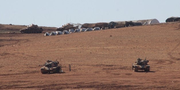 SANLIURFA, TURKEY - OCTOBER 24: As a part of security measures, Turkish Armed Forces dispatch a group of tanks to the near of the Turkish - Syrian border, as the clashes continue in Syria's border town Ayn al Arab (Kobani), between the Islamic State of Iraq and Levant (ISIL) militants and some Kurdish armed groups , in Suruc district of Sanliurfa, southeastern city of Turkey on October 24, 2014. (Photo by Halil Fidan/Anadolu Agency/Getty Images)