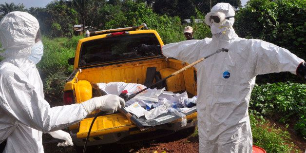 A health worker sprays disinfectant onto a college after they worked with the body of a man, suspected of contracting and dying form the Ebola virus on the outskirts of Monrovia, Liberia, Monday, Oct. 27, 2014. The United States will help fight Ebola over "the long haul," the American ambassador to the United Nations said on a trip to the West African countries hit by the outbreak.(AP Photo/Abbas Dulleh)