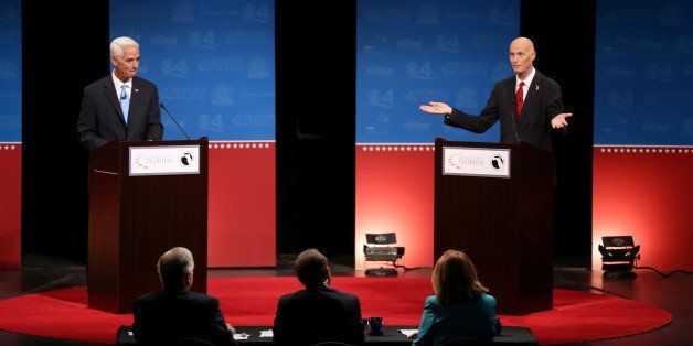 DAVIE, FL - OCTOBER 15: Former Florida Governor and Democratic candidate for Governor Charlie Crist (L) and Republican Florida Governor Rick Scott participate in a televised debate at Broward College on October 15, 2014 in Davie, Florida. Governor Scott is facing off against Crist in the November 4, 2014 governors race. (Photo by Joe Raedle/Getty Images)