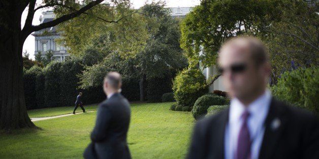 US Secret Service officers stand watch as US President Barack Obama returns to the Oval Office at the White House in Washington, DC, October 14, 2014. AFP PHOTO / Jim WATSON (Photo credit should read JIM WATSON/AFP/Getty Images)