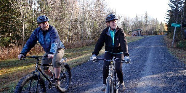 Nurse Kaci Hickox, right, and her boyfriend, Ted Wilbur ride bikes on a trail near her home in Fort Kent, Maine, Thursday, Oct. 30, 2014. The couple went on an hour-long ride followed by a Maine State Trooper. State officials are going to court to keep Hickox in quarantine for the remainder of the 21-day incubation period for Ebola that ends on Nov. 10. Police are monitoring her, but can't detain her without a court order signed by a judge.( AP Photo/Robert F. Bukaty)