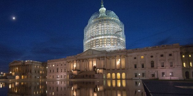 The US Capitol in scaffolding is reflected in a water pool on October 28, 2014 in Washington, DC. The US Capitol dome will undergo its first comprehensive repairs in more than half a century this autumn, installing a donut-shaped canopy to protect visitors to the historic structure. The two-year, USD 60 million project is aimed at repairing nearly 1,300 cracks that have emerged in the nine-million-pound (4.1-million-kilogram) cast iron dome, according to the Architect of the Capitol (AOC) office. Construction on the dome began in 1855. Work symbolically continued through the US Civil War and the structure was eventually completed in 1866. AFP Photo/Paul J. Richards (Photo credit should read PAUL J. RICHARDS/AFP/Getty Images)