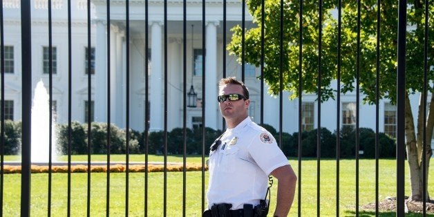 A member of the US Secret Service Uniformed Division patrols in front of the White House in Washington on October 25, 2014. For once, the debate gripping Washington is not about party politics. It's about the White House fence. Is it high enough? Should it be electrified? Are tourists allowed to get too close to the building? After a series of security lapses that raised questions about the safety of the US president, do authorities need to change or reconsider the fence surrounding the First Family's residence in the heart of the city? But the spectacular breach that saw an Iraq war veteran sprint across the White House lawn in mid-September and enter the building with a knife in his pocket has rattled the US Secret Service, which is tasked with protecting the president. AFP PHOTO/Nicholas KAMM (Photo credit should read NICHOLAS KAMM/AFP/Getty Images)