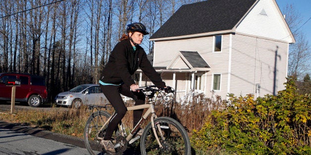 Nurse Kaci Hickox rides away from the home she is staying in on a rural road in Fort Kent, Maine, to take a bike ride, Thursday, Oct. 30, 2014. Hickox went on an hour-long ride with her boyfriend Ted Wilbur, followed by state police who were monitoring her movements and public interactions.( AP Photo/Robert F. Bukaty)