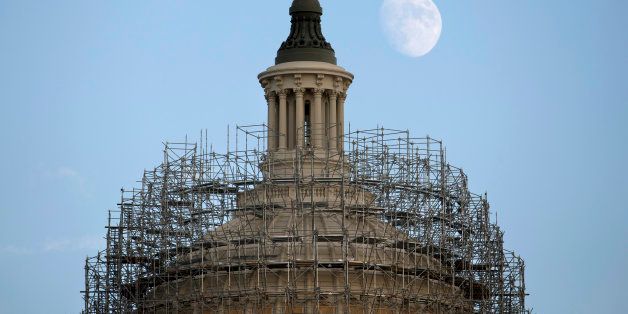 The moon rises over scaffolding-clad Capitol dome in Washington, Monday, Nov. 3, 2014. The scaffolding is part of a long-term repair project to fix cracks, leaks and corrosion in the cast-iron structure of the Dome. (AP Photo/Carolyn Kaster)
