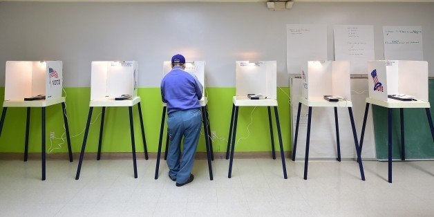 A voter casts his vote at a polling station in Pasadena, California, on November 4, 2014. Months of campaign promises, partisan charges and a seemingly endless flood of political ads and mailers will finally come to an end Tuesday as voters make their choices for offices ranging from governor of California down to city councils, harbor commissions and water boards. AFP PHOTO/Frederic J. BROWN (Photo credit should read FREDERIC J. BROWN/AFP/Getty Images)