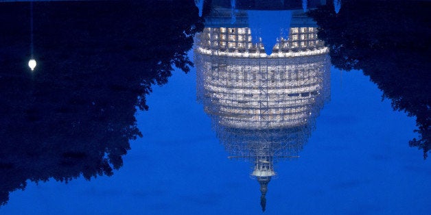 The U.S. Capitol Building is reflected in the Senate reflecting pool while undergoing repairs in Washington, D.C., U.S., on Wednesday, Nov. 5, 2014. Republicans roared back in the midterm elections on Tuesday, capturing control of the Senate from Democrats, winning crucial governor races and solidifying their majority in the U.S. House. Photographer: Andrew Harrer/Bloomberg via Getty Images