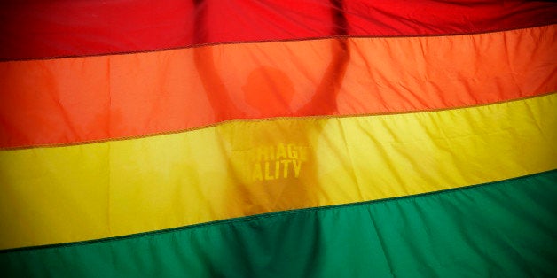 FILE - In this June 26, 2013, file photo, Sean Lewrence, of Philadelphia, holds up a flag during a rally for gay marriage, on Independence Mall in Philadelphia. A federal appeals court on Thursday, Nov. 6. 2014, upheld anti-gay marriage laws in four states, breaking ranks with other courts that have considered the issue and setting up the prospect of Supreme Court review. (AP Photo/Matt Slocum, File)