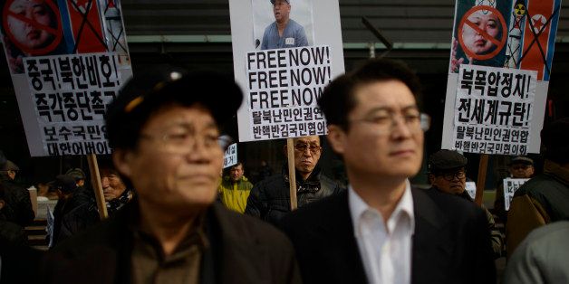 A conservative anti-North Korean activist (C) holds a placard calling for the release of detained US missionary Kenneth Bae during a protest against the North Korean regime, in Seoul on Febraury 16, 2014. Rare talks between the rival Koreas ended on an even rarer note of agreement February 14, allowing an under-threat reunion for divided families to go ahead and fuelling hopes of further constructive engagement. AFP PHOTO / Ed Jones (Photo credit should read ED JONES/AFP/Getty Images)