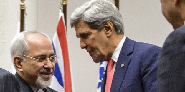 ALTERNATIVE CROPIranian Foreign Minister Mohammad Javad Zarif (2nd L) shakes hands with US Secretary of State John Kerry as they stand next to French Foreign Minister Laurent Fabius (R) after a statement early on November 24, 2013 in Geneva. World powers on November 24 agreed a landmark deal with Iran halting parts of its nuclear programme in what US President Barack Obama called 'an important first step'. According to details of the accord agreed in Geneva provided by the White House, Iran has committed to halt uranium enrichment above purities of five percent. AFP PHOTO / FABRICE COFFRINI (Photo credit should read FABRICE COFFRINI/AFP/Getty Images)