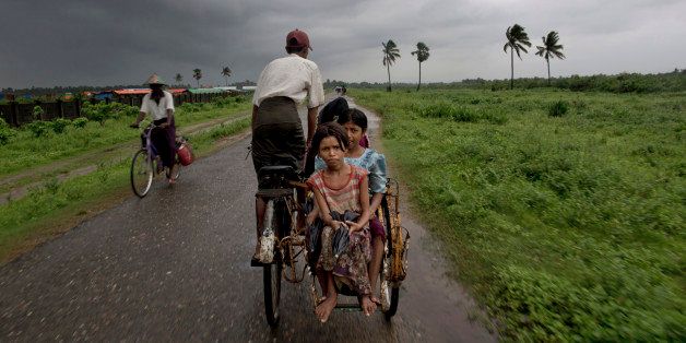 In this June 26, 2014 photo, Rohingya children travel in a rickshaw in north of Sittwe, Rakhine State, Myanmar. A growing sense of desperation is fueling a mass exodus of Rohingya Muslims from western Myanmar, with at least 8,000 members of the long-persecuted minority fleeing by boat in the last two weeks, according to an expert. (AP Photo/Gemunu Amarasinghe)