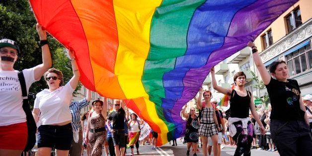 Participants carrying a rainbow-colored flag attend the annual Stockholm Pride parade, the climax to the week-long Pride festival in Stockholm, Saturday, Aug. 2, 2014. The parade attracted many thousands of participants and more than 600 000 spectators thronged the streets to watch. (AP Photo/Annika AF Klercker, TT News Agency) SWEDEN OUT