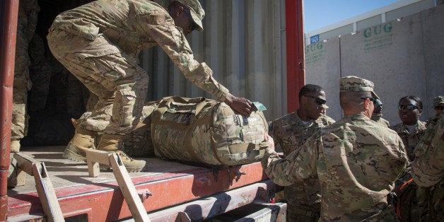 KANDAHAR, AFGHANISTAN - NOVEMBER 14: US Army guardsmen load a lorry with their luggage as they leave at the end of their tour at Kandahar airfield on November 14, 2014 in Kandahar, Afghanistan. Now that British combat operations have ended and the last UK base in Afghanistan had been handed over to the control of Afghan security forces, any remaining troops are leaving the country via Kandahar. As the drawdown of the US-led coalition troops heads into its final stages, many parts of Kandahar airfield, once home to tens of thousands of soldiers and contractors, are being closed or handed over to the Afghans. (Photo by Matt Cardy/Getty Images)