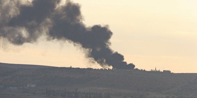 SANLIURFA, TURKEY - NOVEMBER 03: A photo taken in Suruc district of Sanliurfa, Turkey shows smoke rises from an explosion in the Syrian border town of Kobani (Ayn al-Arab) following a US-led coalition airstrike hits an Islamic State of Iraq and the Levant (ISIL) targets on November 3, 2014. (Photo by Ali Ihsan Ozturk/Anadolu Agency/Getty Images)