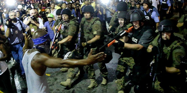 FILE - In this Aug. 20, 2014 file photo police arrest a man as they disperse a protest against the shooting of Michael Brown