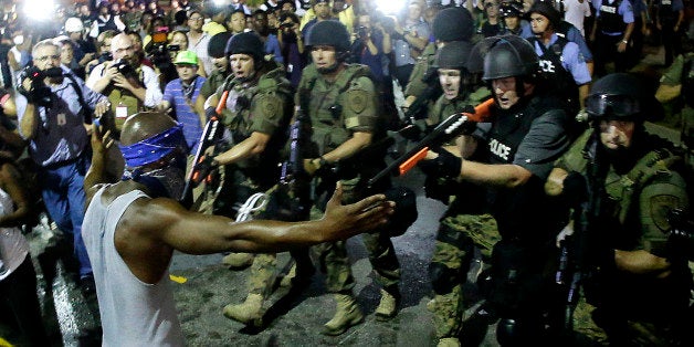 FILE - In this Aug. 20, 2014 file photo police arrest a man as they disperse a protest against the shooting of Michael Brown in Ferguson, Mo. Since the Aug. 9 shooting death of the black 18-year-old by white police officer Darren Wilson, protesters have invested their time decrying the killing as an illustration of racial inequities in the nation's policing. Now, thousands from New York to California and points overseas are investing their money _ in staggering amounts, as contributions to Brown's family and Wilson. (AP Photo/Charlie Riedel, File)