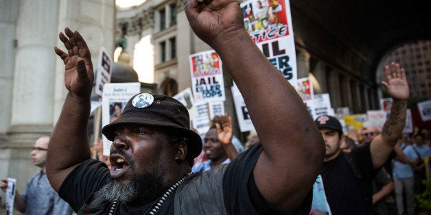 NEW YORK, NY - AUGUST 18: Protesters hold a rally in solidarity with the people in Ferguson, Missouri protesting the death of Michael Brown and the excessive use of force by police on August 18, 2014 in New York City. A few dozen protesters marched to City Hall, held up signs and chanted rally cries including, 'Hands up, don't shoot!' (Photo by Andrew Burton/Getty Images)