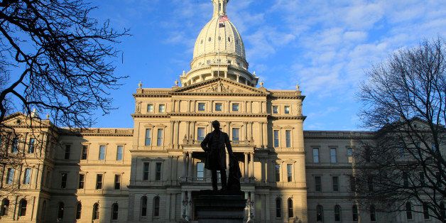 The statue of Gov. Austin Blair, the war governor (1861- 1864), is silhouetted against the state Capitol in Lansing, Mich., Wednesday, Dec. 12, 2012, a day after thousands of protesters rallied on the grounds as lawmakers pushed final versions of right-to-work legislation. (AP Photo/Carlos Osorio)