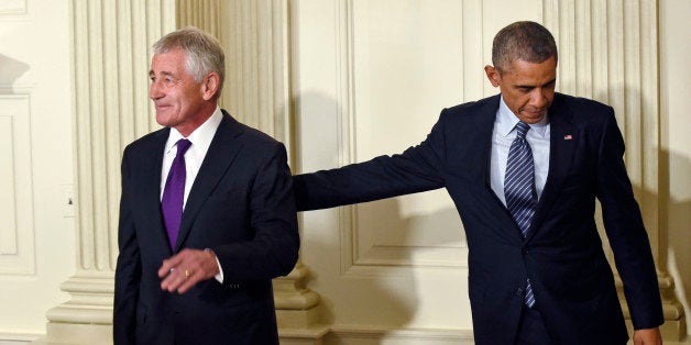 President Barack Obama, left, reaches over to touch Defense Secretary Chuck Hagel, left, following an announcement of Hagel's resignation during an event in the State Dining Room of the White House in Washington, Monday, Nov. 24, 2014. Hagel is stepping down under pressure from Obama's Cabinet, senior administration officials said Monday, following a tenure in which he has struggled to break through the White House's insular foreign policy team. (AP Photo/Susan Walsh)